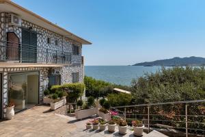 a house with potted plants in front of the ocean at Hotel Villa Nisteri in Limenas