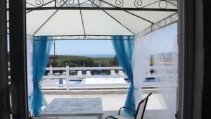 a view from a window of a patio with blue curtains at Luštica Apartments in Luštica