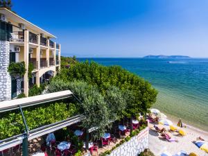a view of a hotel and the beach with chairs and umbrellas at Hotel Villa Nisteri in Limenas