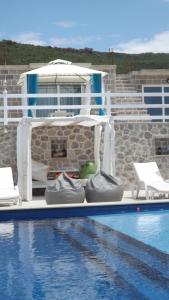 a swimming pool with two chairs and a swimming pool at Luštica Apartments in Luštica