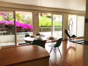 a dining room with a table and chairs and a balcony at Le Solemar in Cassis
