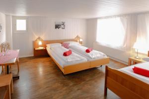 sypialnia z 2 łóżkami i czerwonymi poduszkami w obiekcie Landgasthof Schlüssel Alpnach w mieście Alpnach