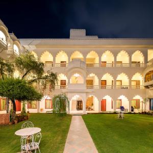 een groot gebouw met een gazon ervoor bij Hotel Rajasthan Palace in Jaipur
