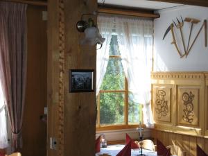 une salle à manger avec un arbre de Noël dans une fenêtre dans l'établissement Swiss Lodge Hotel Bernerhof, à Wengen