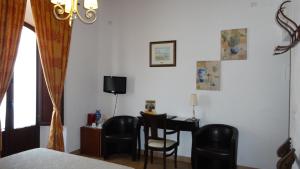 a bedroom with a desk and a table and chairs at La Posada Del Infante in La Puebla de los Infantes