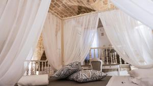 a bedroom with white curtains and pillows on the floor at L'IMPERATORE Relax & Charme in Altamura