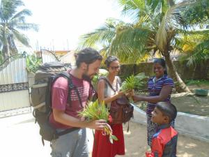 a man and two women and a child holding plants at El Shaddai in Mannar