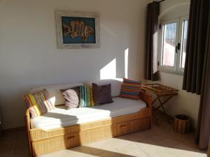 トリニタ・ダグルトゥにあるSardegna Isola Rossa panoramiccissimoのカラフルな枕付きのソファが備わる客室です。