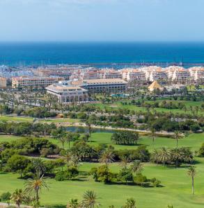 z góry widok na ośrodek z palmami i ocean w obiekcie Hotel AR Golf Almerimar w Almerimar