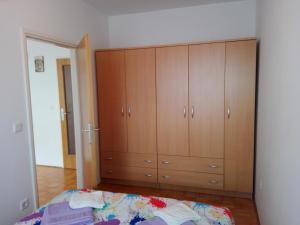 sypialnia z łóżkiem i drewnianymi szafkami w obiekcie Apartman Miškulin w mieście Senj