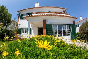a house with flowers in front of it at Liv In Ericeira Guest House in Ericeira