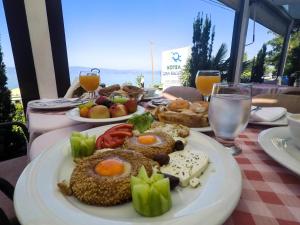 a table with plates of food and drinks on it at Hotel Dva Bisera in Ohrid