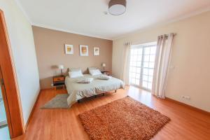 a bedroom with a bed and a large window at Liv In Ericeira Guest House in Ericeira