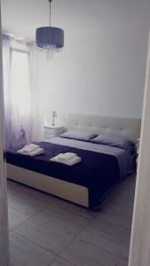 una camera da letto con un grande letto con lenzuola blu e una finestra di B&BWHITE a Ugento
