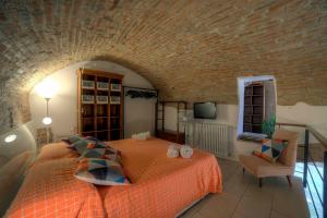 sypialnia z dużym łóżkiem z pomarańczową narzutą w obiekcie Stilnuovo Charming Apartment in Siena's Historic Center, Very Close to Piazza del Campo w Sienie