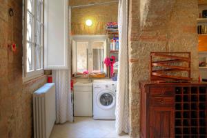 kuchnia z pralką i suszarką w pokoju w obiekcie Stilnuovo Charming Apartment in Siena's Historic Center, Very Close to Piazza del Campo w Sienie
