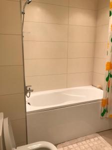łazienka z wanną i toaletą w obiekcie Apartments in Vabaduse 72 w mieście Narva-Jõesuu
