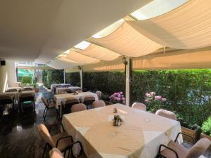 une rangée de tables et de chaises sous parasols dans l'établissement Hotel Dva Bisera, à Ohrid