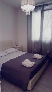 una camera da letto con un letto e due asciugamani di B&BWHITE a Ugento
