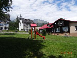 a playground in a yard with a red slide at Apartmány Hágy L+L in Vysoké Tatry