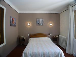 - une chambre avec un lit et deux lumières sur le mur dans l'établissement Hôtel Le Castelet, à Ax-les-Thermes