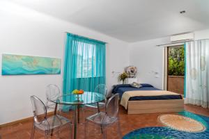 陶爾米納的住宿－Medea Residence appartamenti vacanze，一间卧室配有一张床和一张玻璃桌子及椅子