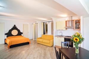1 dormitorio con cama, mesa y cocina en Medea Residence appartamenti vacanze en Taormina