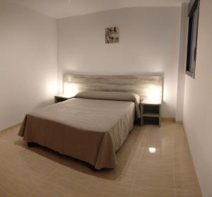 a bedroom with a bed and two night stands at Apartamentos Prado in Peniscola