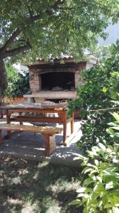 stół piknikowy i kominek w parku w obiekcie Apartman Iva w mieście Zadar
