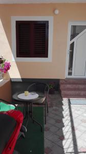 patio ze stołem i krzesłami oraz oknem w obiekcie Apartman Iva w mieście Zadar