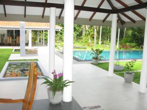 a patio with a table and chairs and a swimming pool at Anuhas Airport Villas in Katunayaka