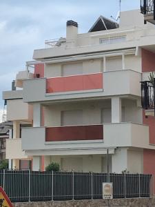 un edificio alto con una valla delante en Appartamento Shanaia, en Loano