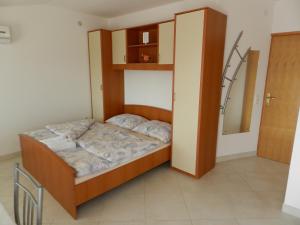 a small bed in a room with a mirror at Apartmani Lucija Jurković in Malinska