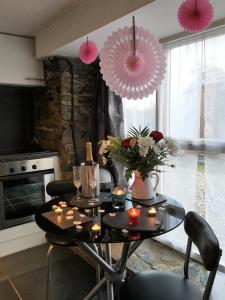 una habitación con una mesa con flores y globos rosas en The Barn at Pink Cottage, en Crossgar
