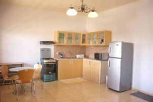 a kitchen with a refrigerator and a table with chairs at Rainville Apartments in Paramaribo +9 photos