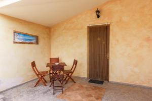 Habitación con mesa, sillas y puerta en Agriturismo Su Solianu, en Bari Sardo