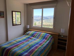 a bedroom with a bed and a large window at Mirador Castillo La Iruela in Cazorla