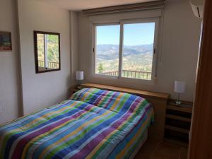 1 dormitorio con cama y ventana grande en Mirador Castillo La Iruela, en Cazorla