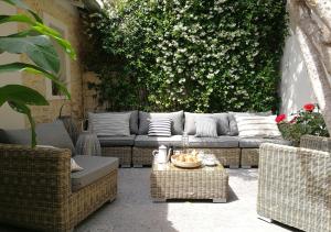 a patio with a couch and wicker chairs at Antichambre in Nîmes