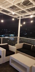 a balcony with couches and a table and lights at Villa Jidah in Gegarbensang