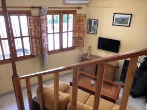 カソルラにあるCasa Chicaのテレビとソファが備わる階段付きの客室です。