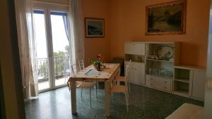 uma sala de jantar com uma mesa e cadeiras e uma janela em Anly Apartment em Cannero Riviera
