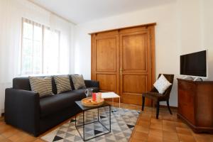 a living room with a black couch and a tv at KAYSERSBERG city center - COTE VIGNOBLE - in Kaysersberg