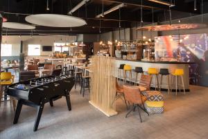 a restaurant with a bar with a table and chairs at Ibis Madrid Fuenlabrada in Fuenlabrada