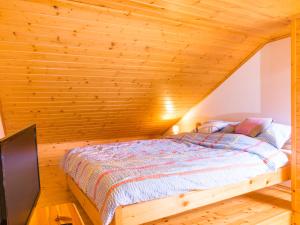 a bed in a room with a wooden ceiling at Apartamenty Osiedle Belweder in Wisła