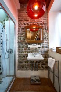 uma casa de banho com uma parede de pedra, um lavatório e um chuveiro. em Centro Storico em Chiari