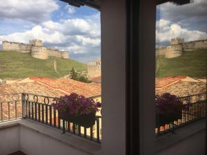 uma vista para um castelo a partir de uma varanda com flores em Hotel Rural Villa de Berlanga em Berlanga de Duero
