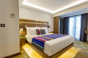 um quarto de hotel com uma cama grande e uma janela em Hay Hotel Alsancak em Esmirna