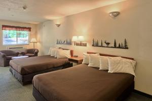 a hotel room with two beds and a chair at The Legend Cottage Inn in Bellaire