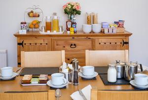 una mesa de comedor con platos y tazas. en Eastdene Guest House, en Inverness